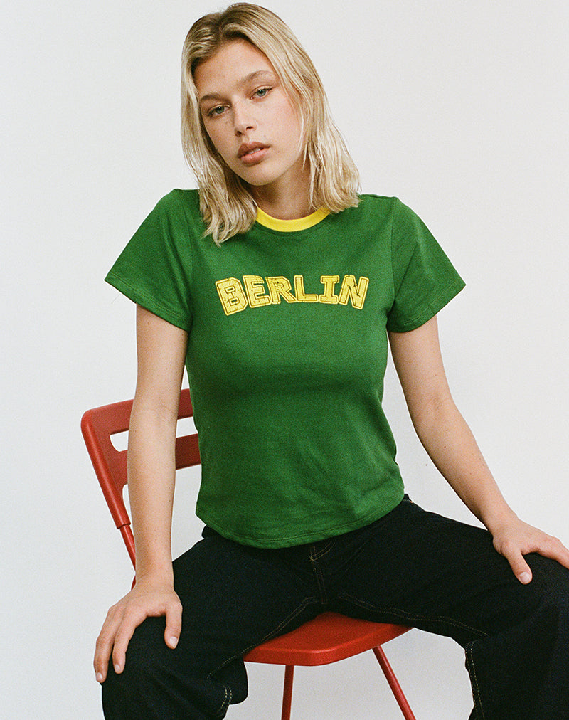 Sakha Boxy Top in Elm Green met gele bies en Berlijnse emblemen